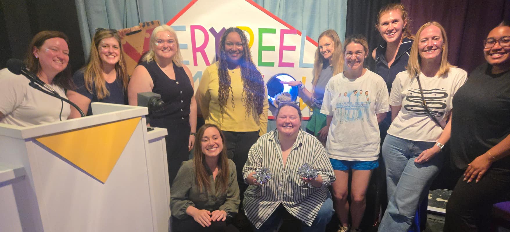 Smiling team posing on stage after an interactive game show