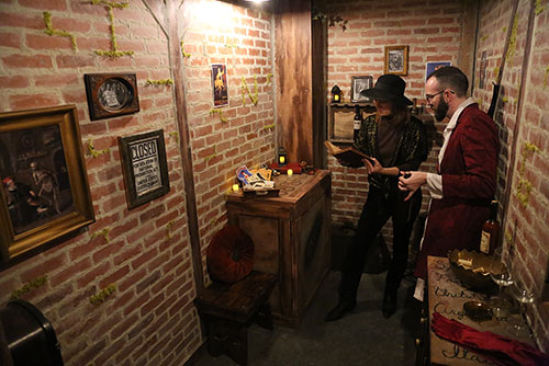 Two people reading a book for clues in the brick-walled Smugglers Den